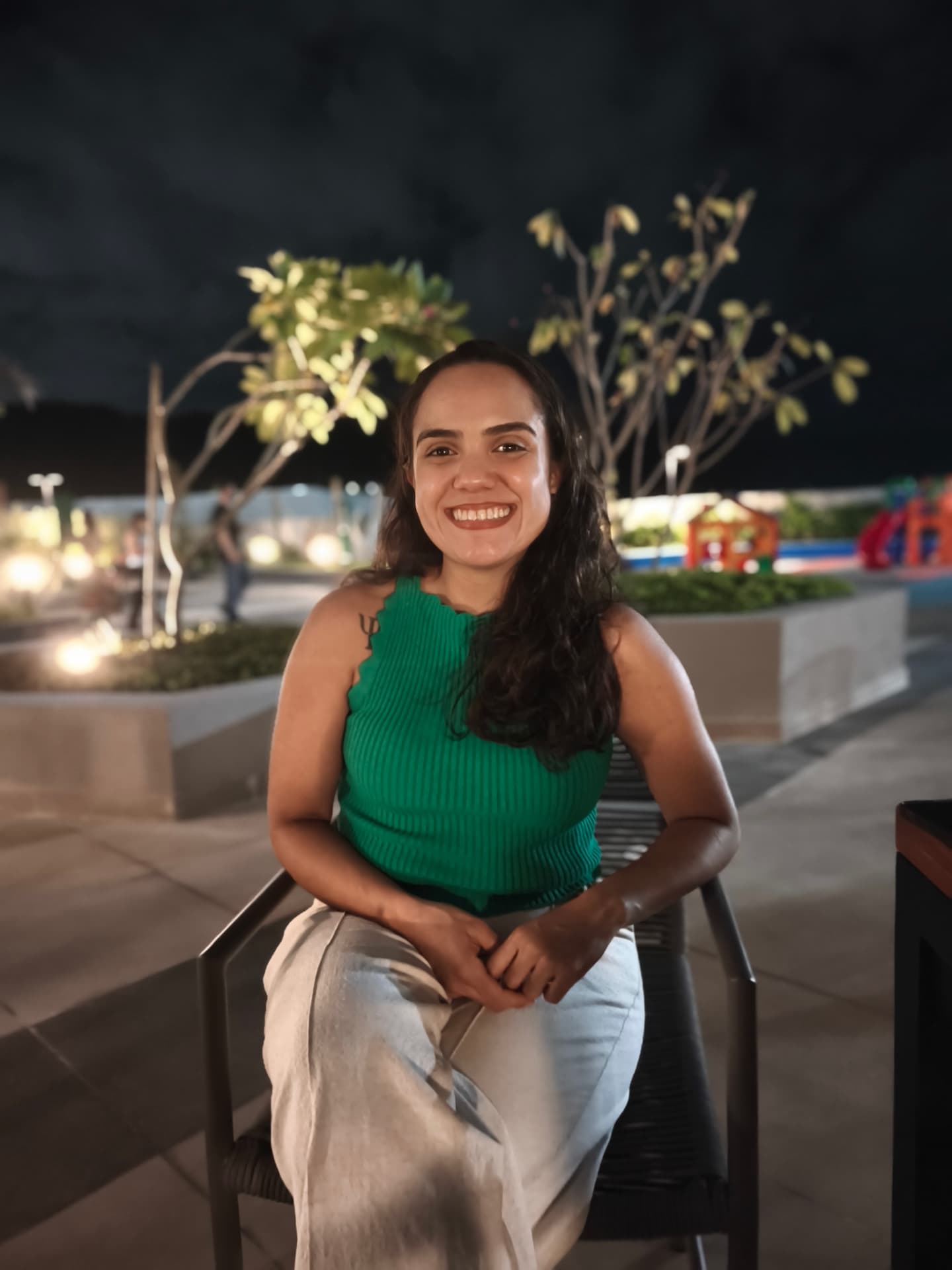 Milena Moura Santos, psicóloga clínica em Santos, sorrindo sentada
